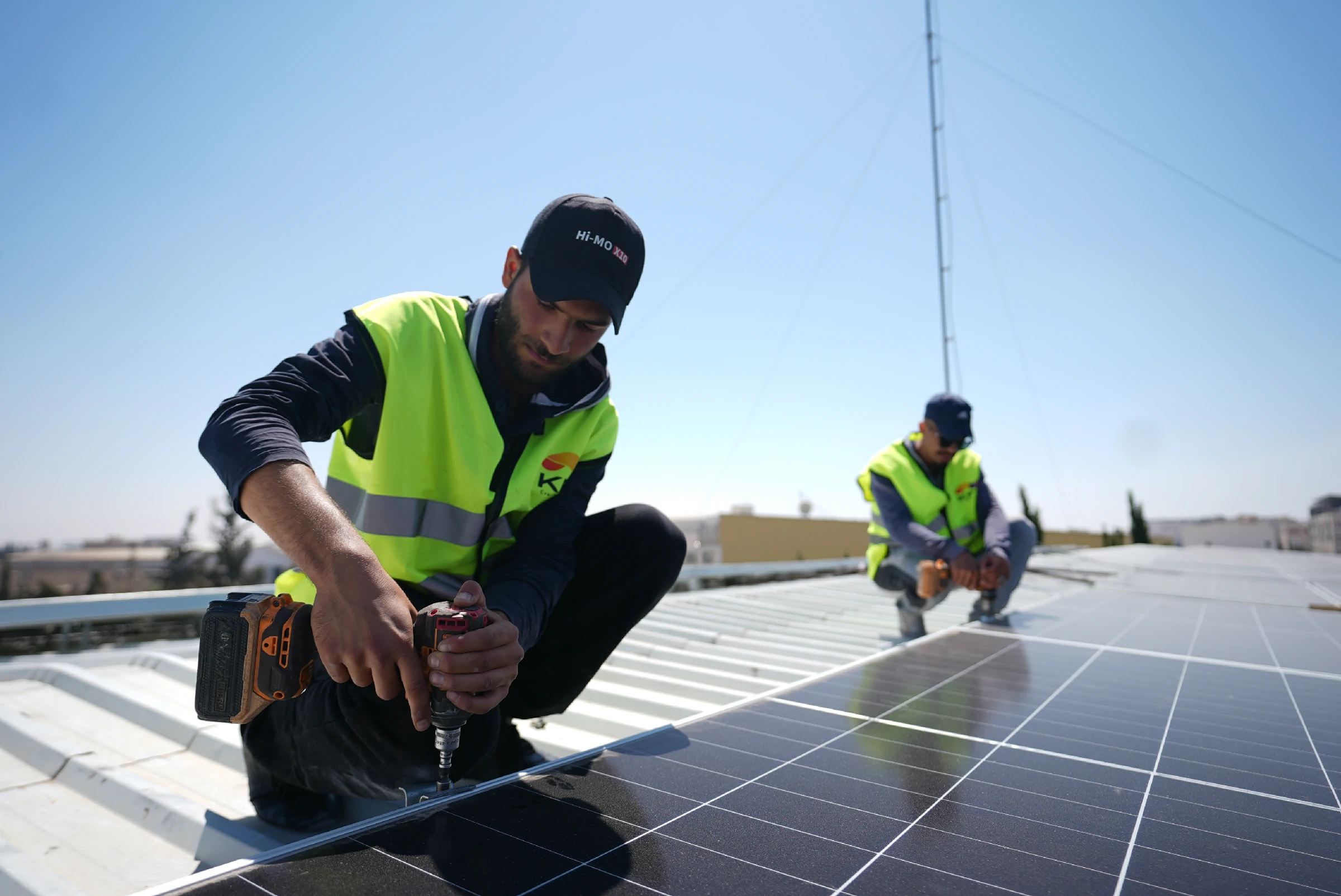 Solar technician installing and wiring photovoltaic panels on site