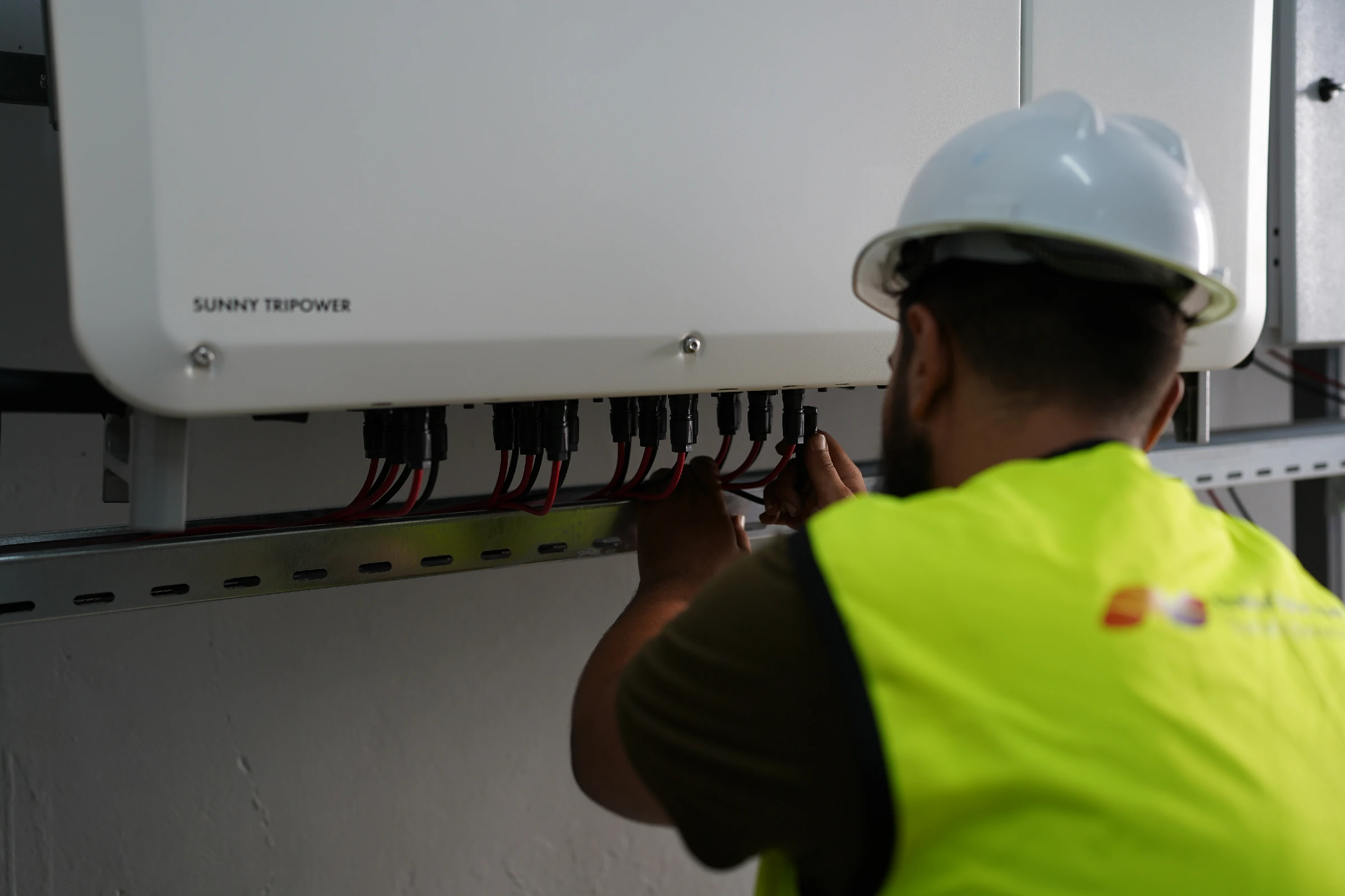 Technician installing a modern solar inverter